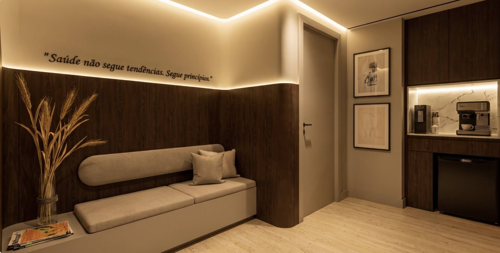 Sala de espera com sofá, painéis de madeira e luz indireta; na parede, uma frase sobre princípios.